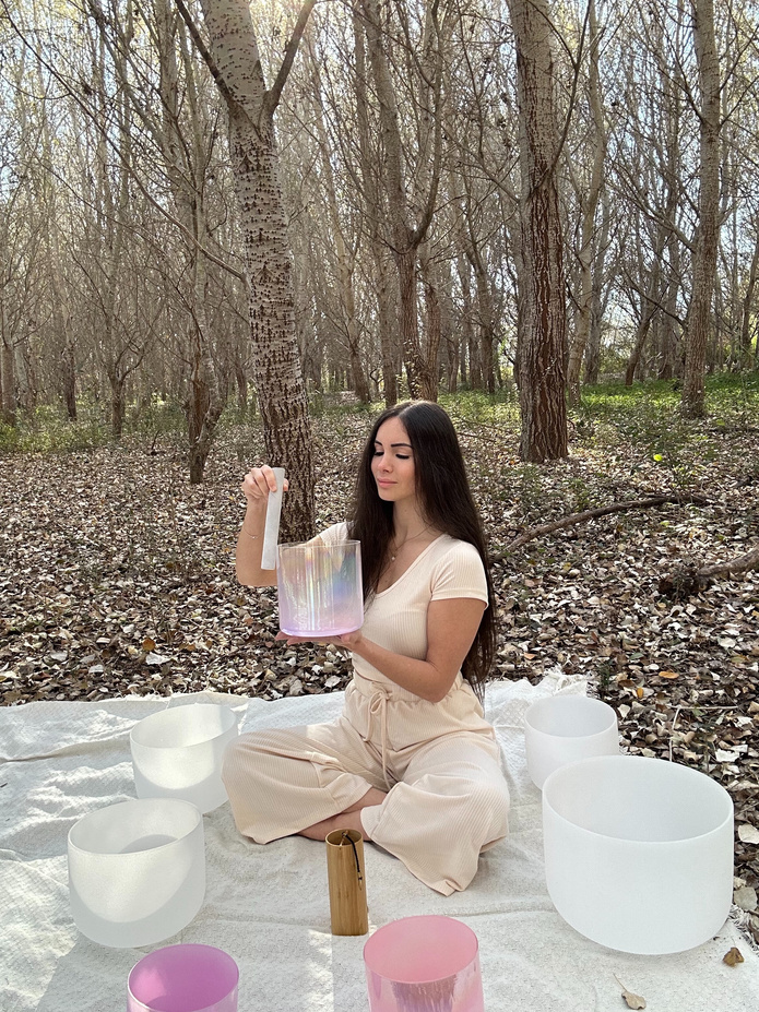 Marta junto a cuencos de cristal en un bosque
