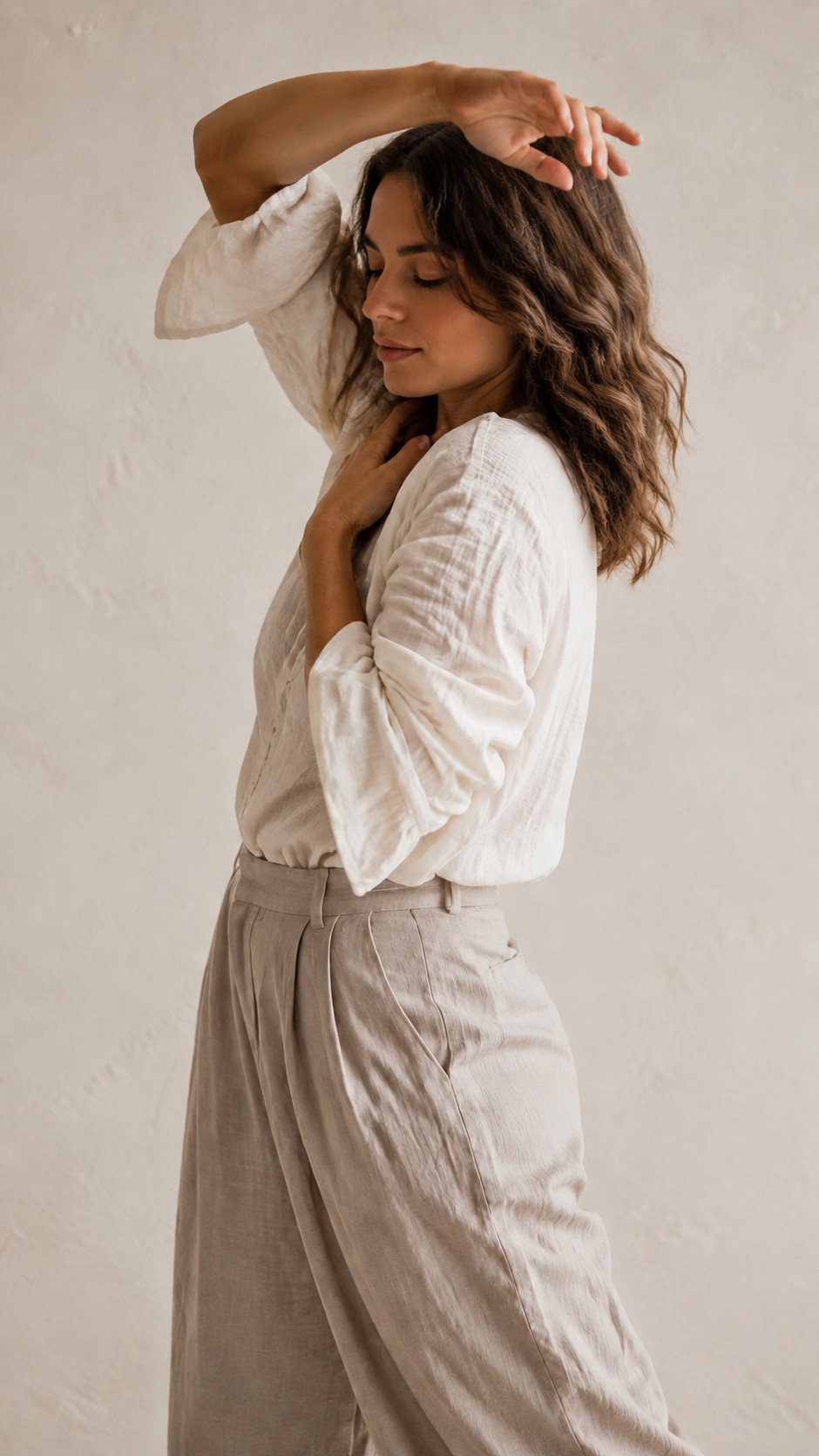 Mujer vestida de blanco con los brazos junto al rostro